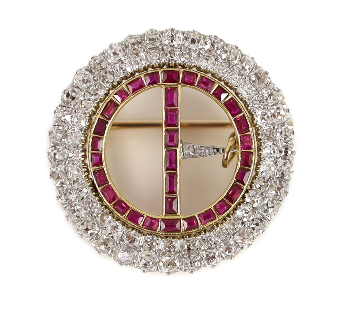 A 20th century gold and platinum, ruby and diamond set openwork circular 'buckle' brooch